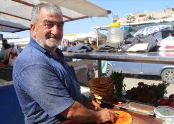 Depremde işletmesi yıkılan Hasan usta, öcce dürümü müşterilerine tezgahta sunuyor