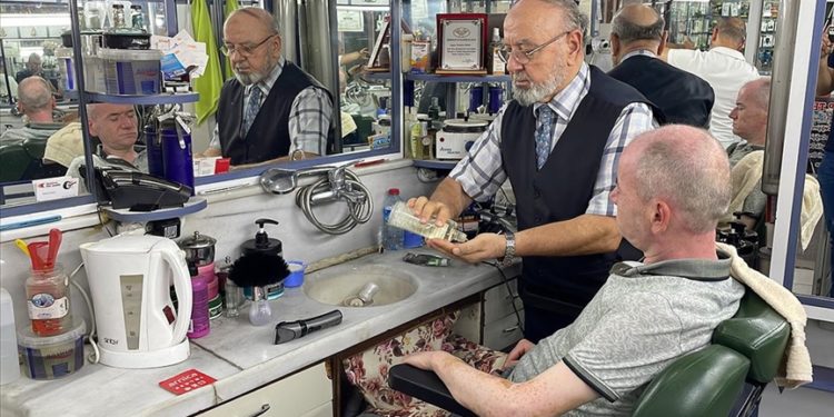 “Yılın Ahisi” seçilen berber, müşterilerine oğluyla hizmet veriyor
